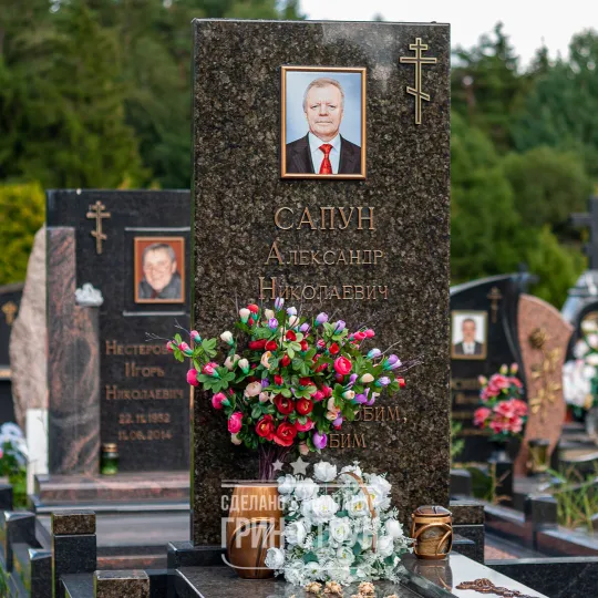 Фото одиночного памятника в самом простом исполнении. Обратите внимание на оригинальный дизайн столбиков оградки.