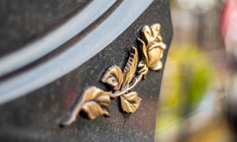 Бронзовый цветок на стеле одиночного памятника