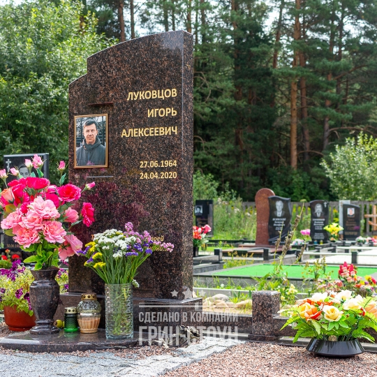 Фото большого памятника мужчине с оригинальным резом стелы под размещение фотомедальона прямоугольной формы. Ограда изготовлена в цвет памятника.