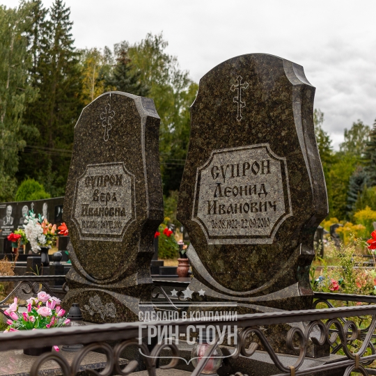 Семейный мемориал из двух одинаковых памятников. Обратите внимание на толщину стел и кованую ограду, выполненную в тон камню.