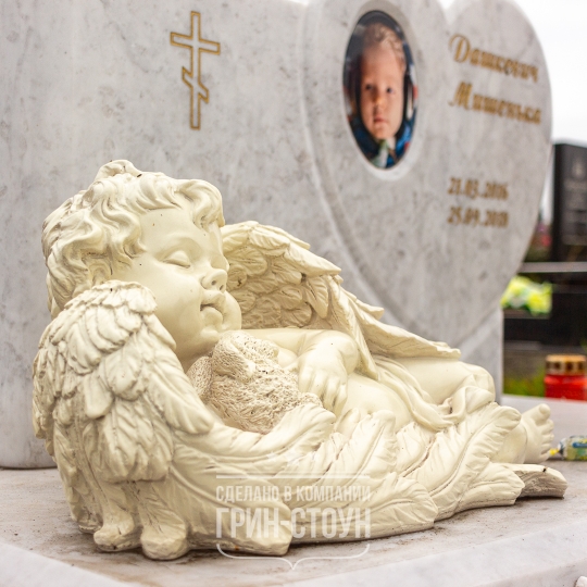 Фото мраморного памятника ребенку. На переднем фоне скульптура ангела, выполненная из полимера.