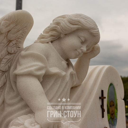 Фрагмент памятника ребенку. Стелу, выполненную из цельной мраморной глыбы, дополняет скульптура ангела.