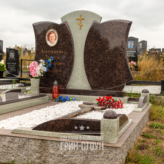 Изображение двойного семейного мемориала из темно-красного и серого камня. Две симметричные стелы неправильной формы и центральный элемент в контрасте.