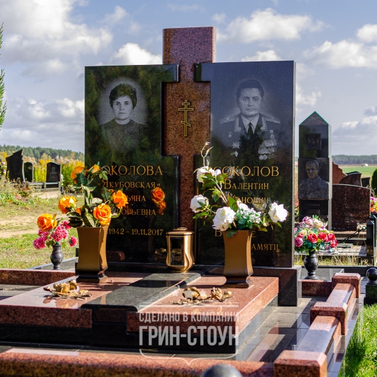 Фото двойного семейного мемориала из красного и черного камня, украшенного бронзовой лампадой