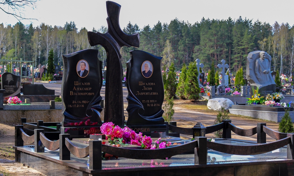 Семейный мемориал в составе двух стел и креста посередине. Гранитная ограда и плитка выдержаны в едином со стелами стиле.