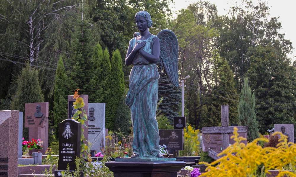 Скульптурная композиция в образе ангела с крыльями на массивном постаменте в виде гранитного куба